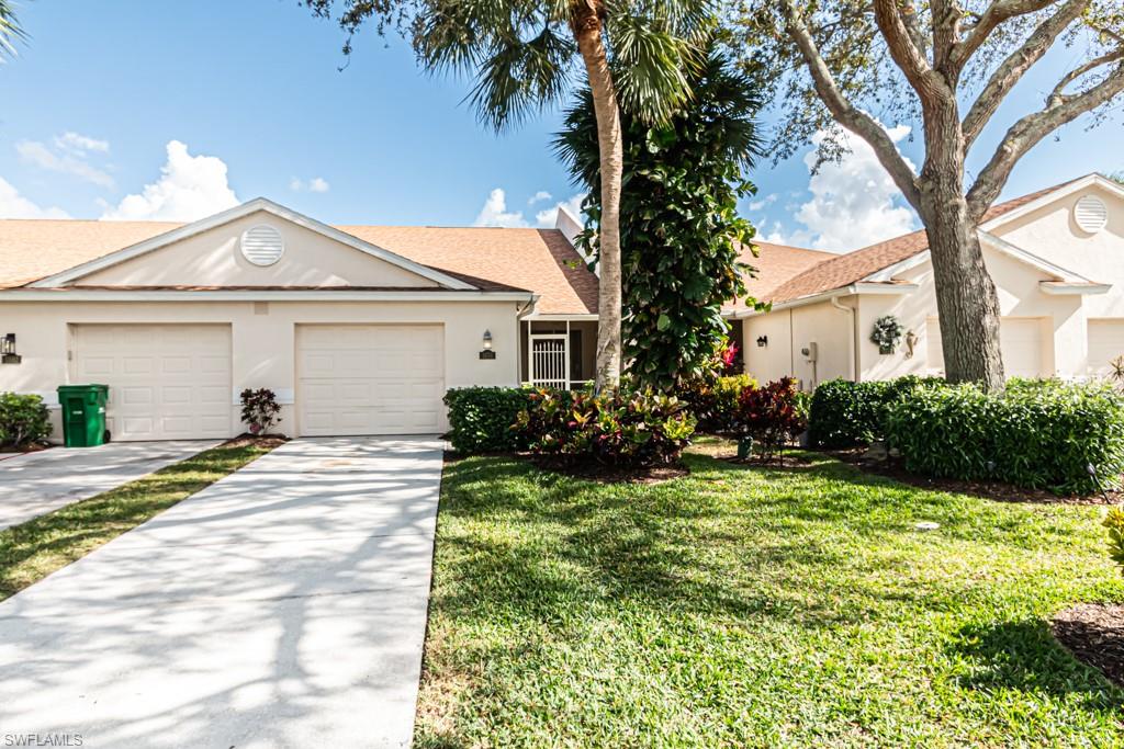 View of front of property with a garage and a front lawn