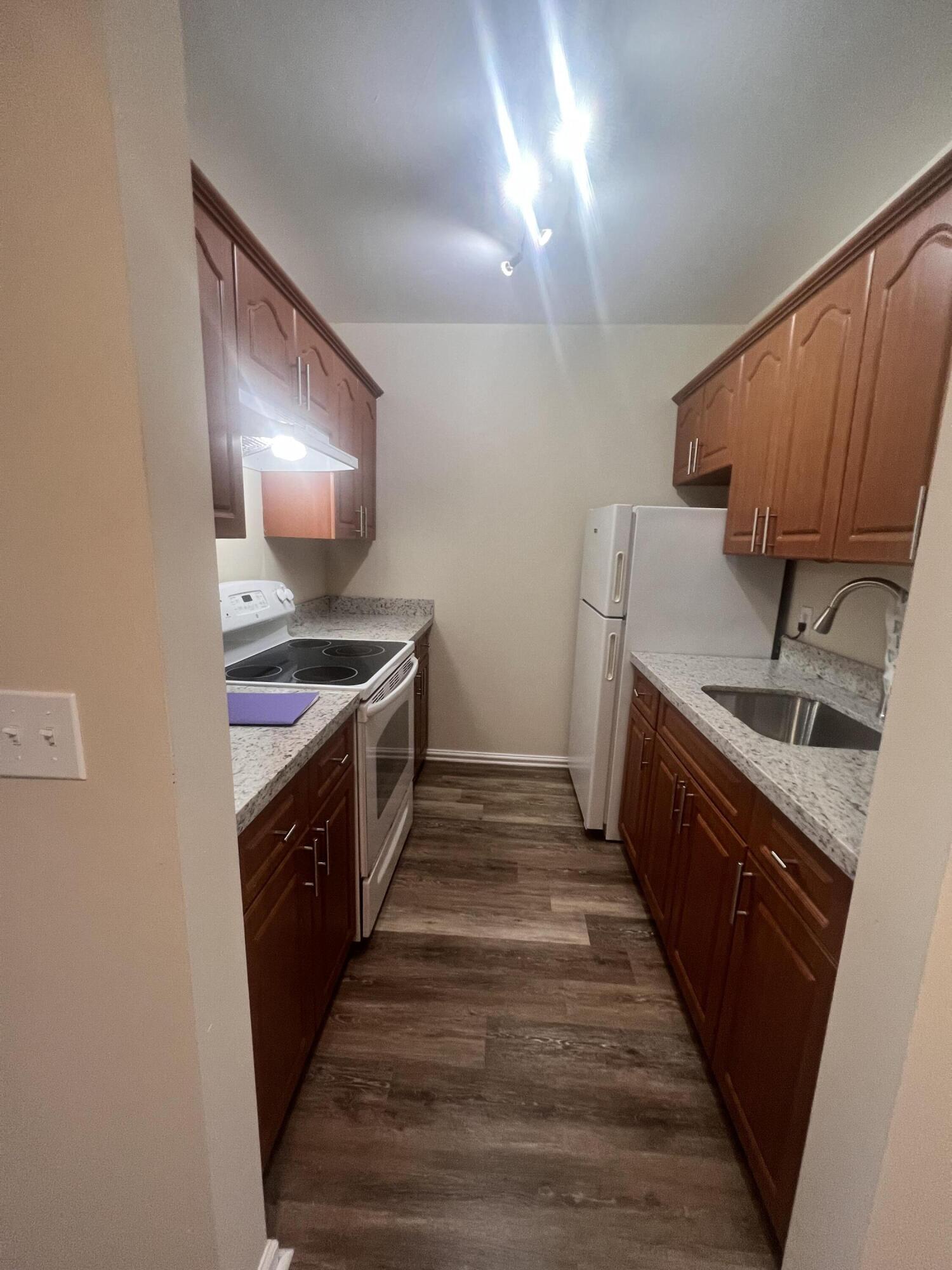 a kitchen with granite countertop a sink and a stove top oven