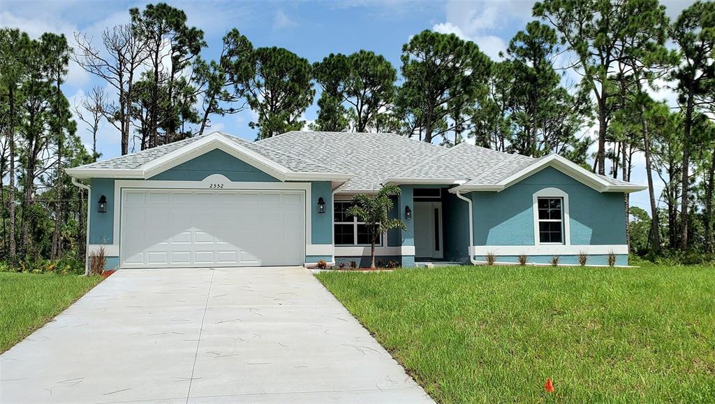 a front view of a house with a yard and trees