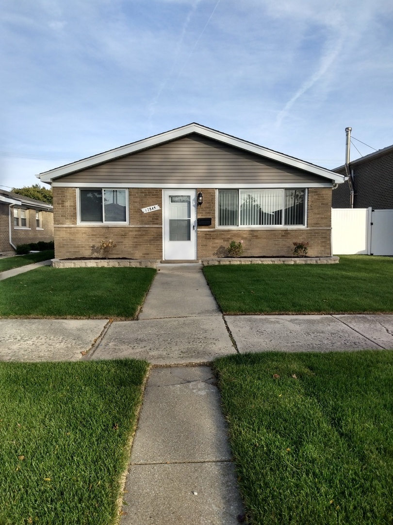 a front view of a house with a garden and yard