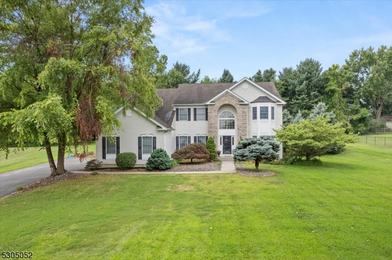 a front view of a house with a yard and trees