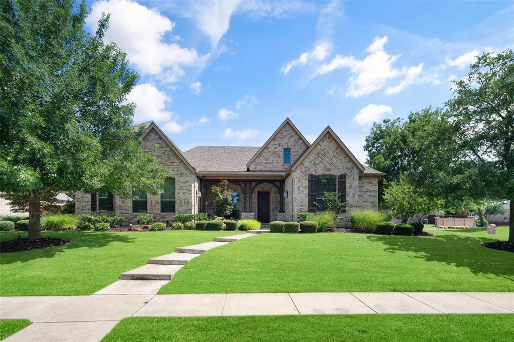 a front view of a house with a yard and trees