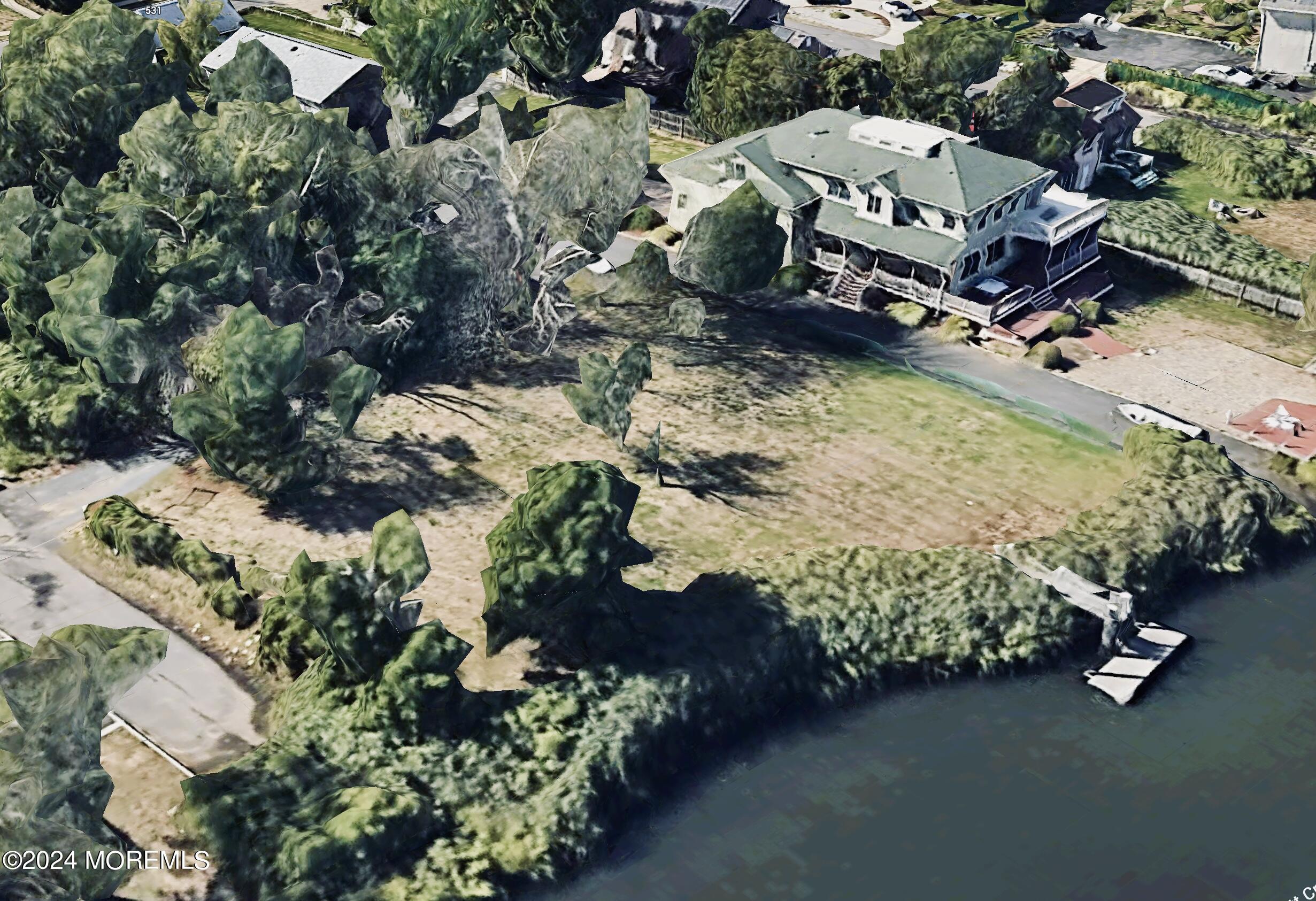 an aerial view of a house with a yard and lake view