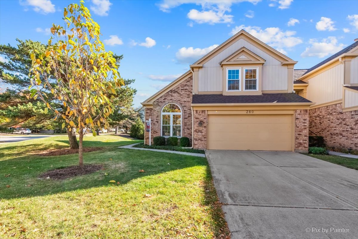 a front view of a house with a yard and garage