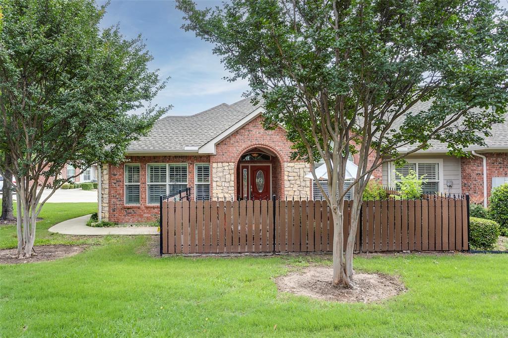 a front view of a house with yard and tree