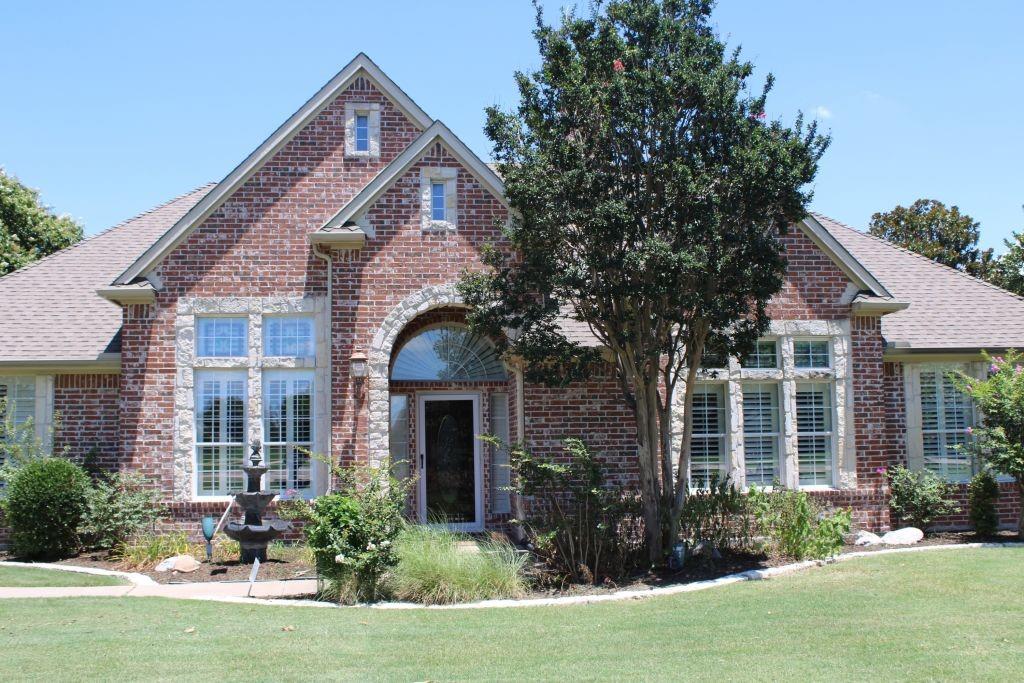 a front view of a house with yard and green space