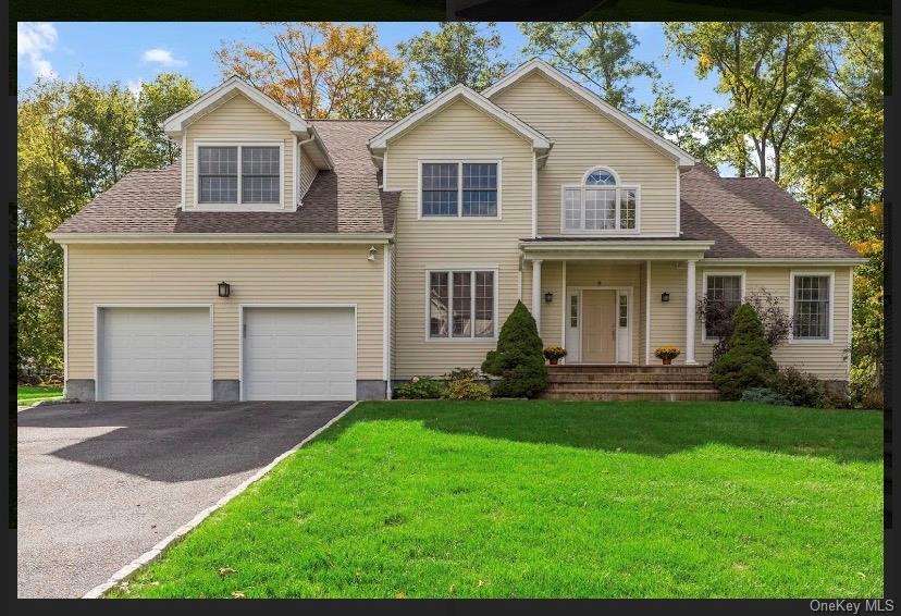 View of front of property featuring a front yard and a garage