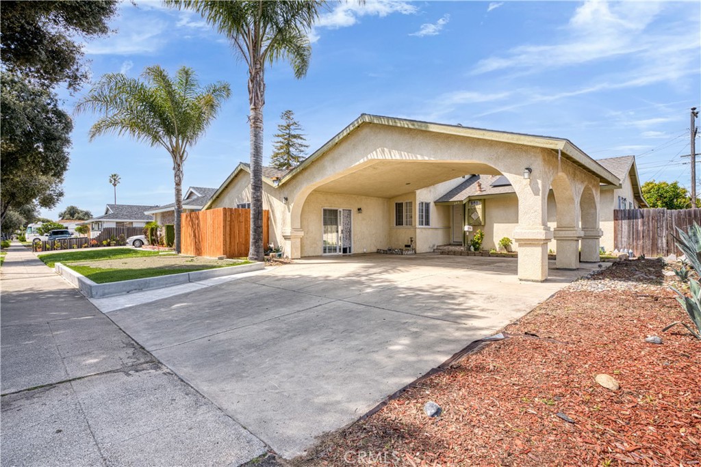 a view of a house with a yard and palm trees