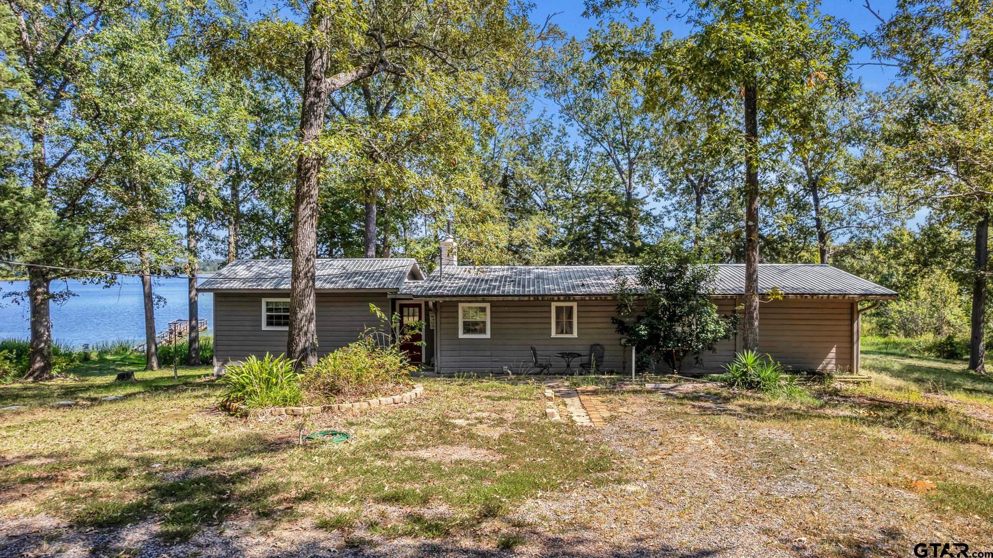 a view of a house with a yard and large tree