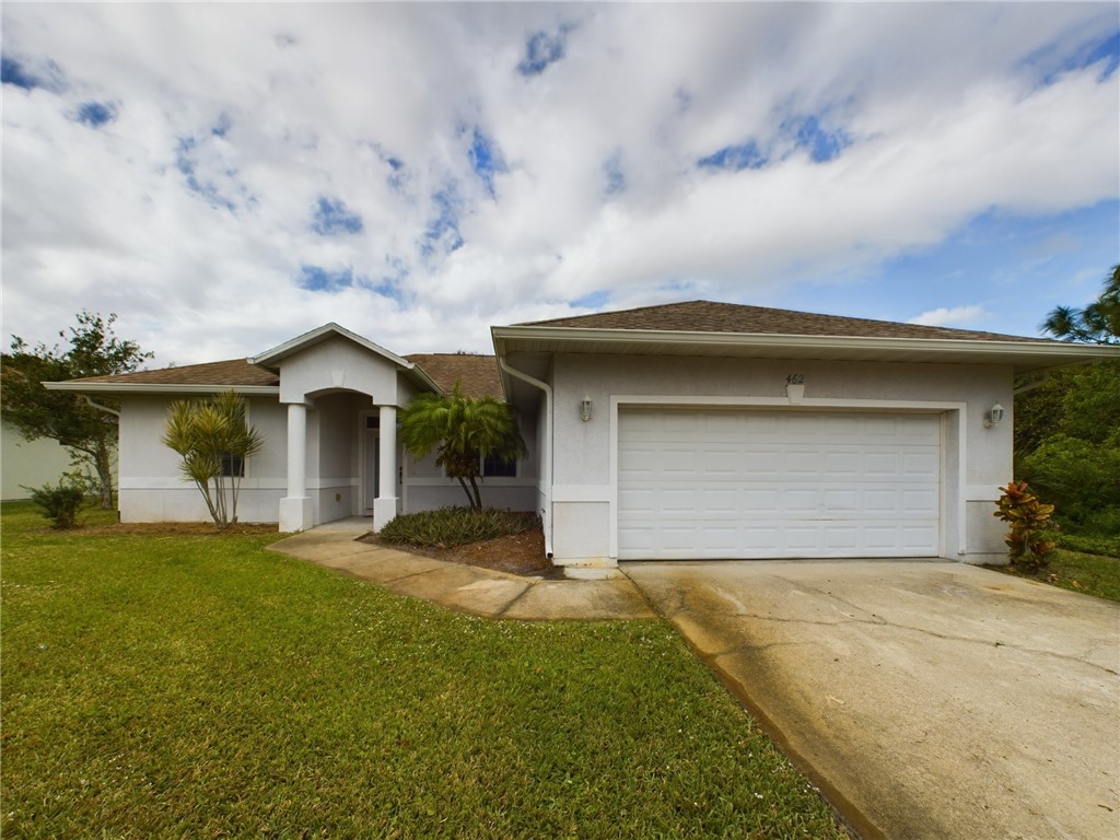 a view of a house with a yard and garage