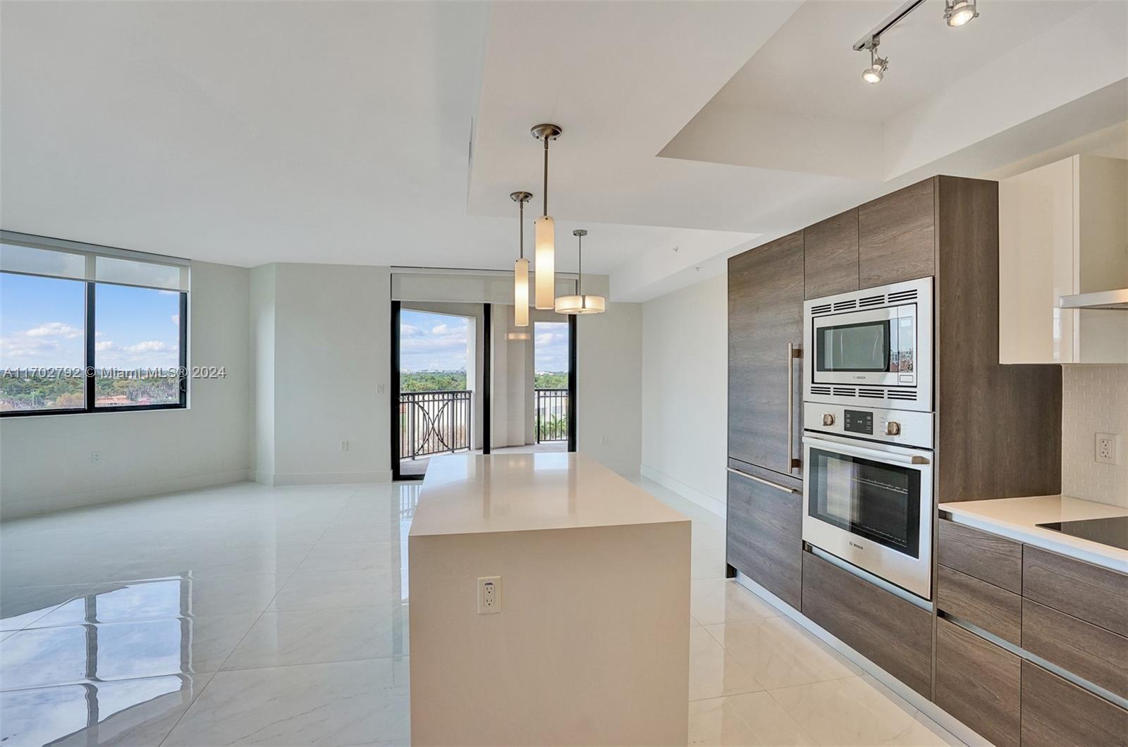 a kitchen with stainless steel appliances kitchen island granite countertop a stove and a refrigerator