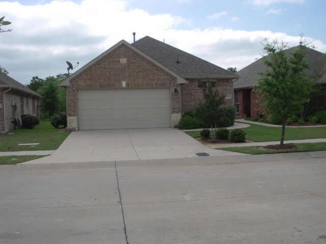 a front view of house with garage and trees