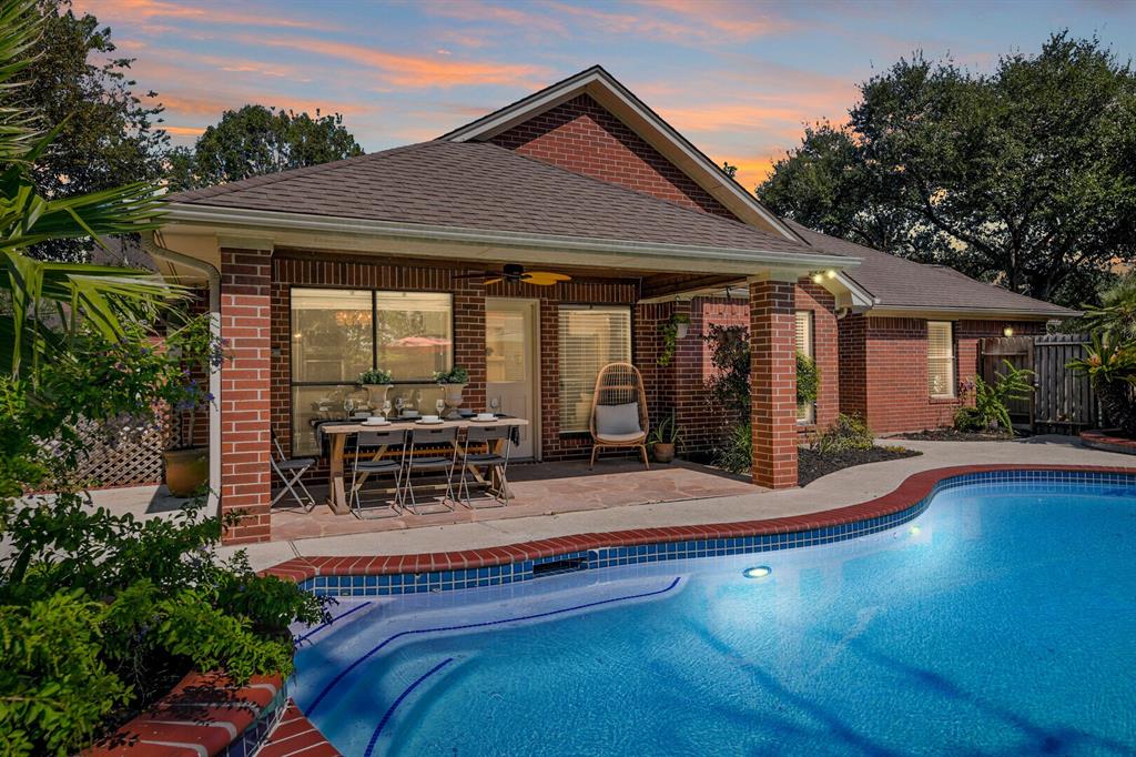 a view of a house with pool and sitting area