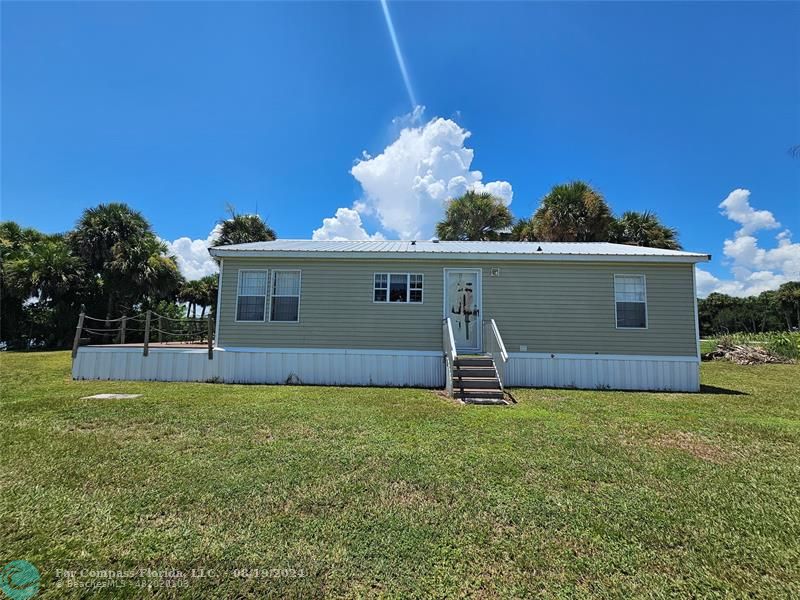 a view of a house with a yard and a porch