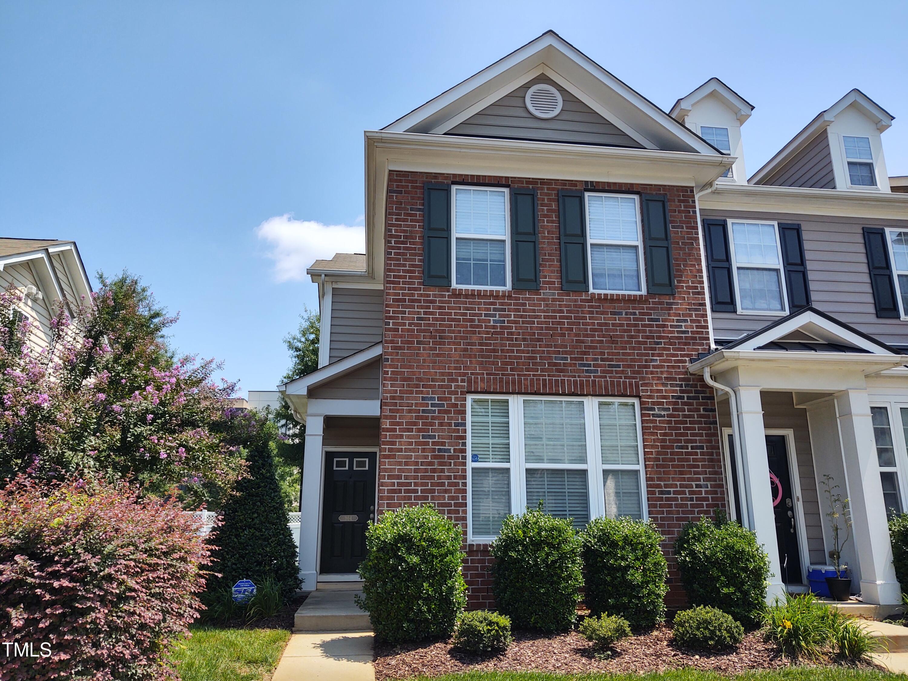 front view of a brick house with a yard