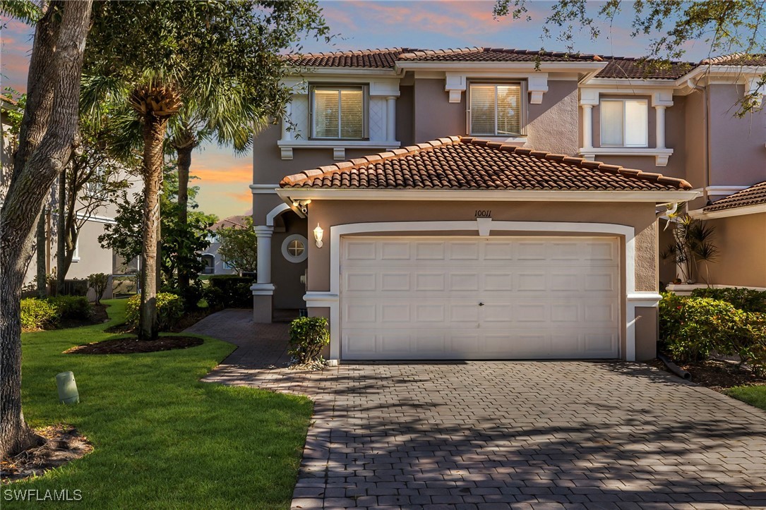 a front view of a house with a yard and garage