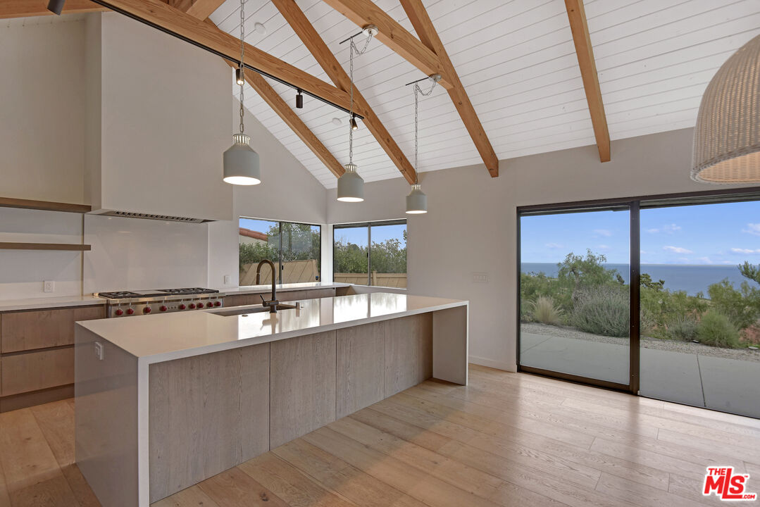 a large white kitchen with a large window