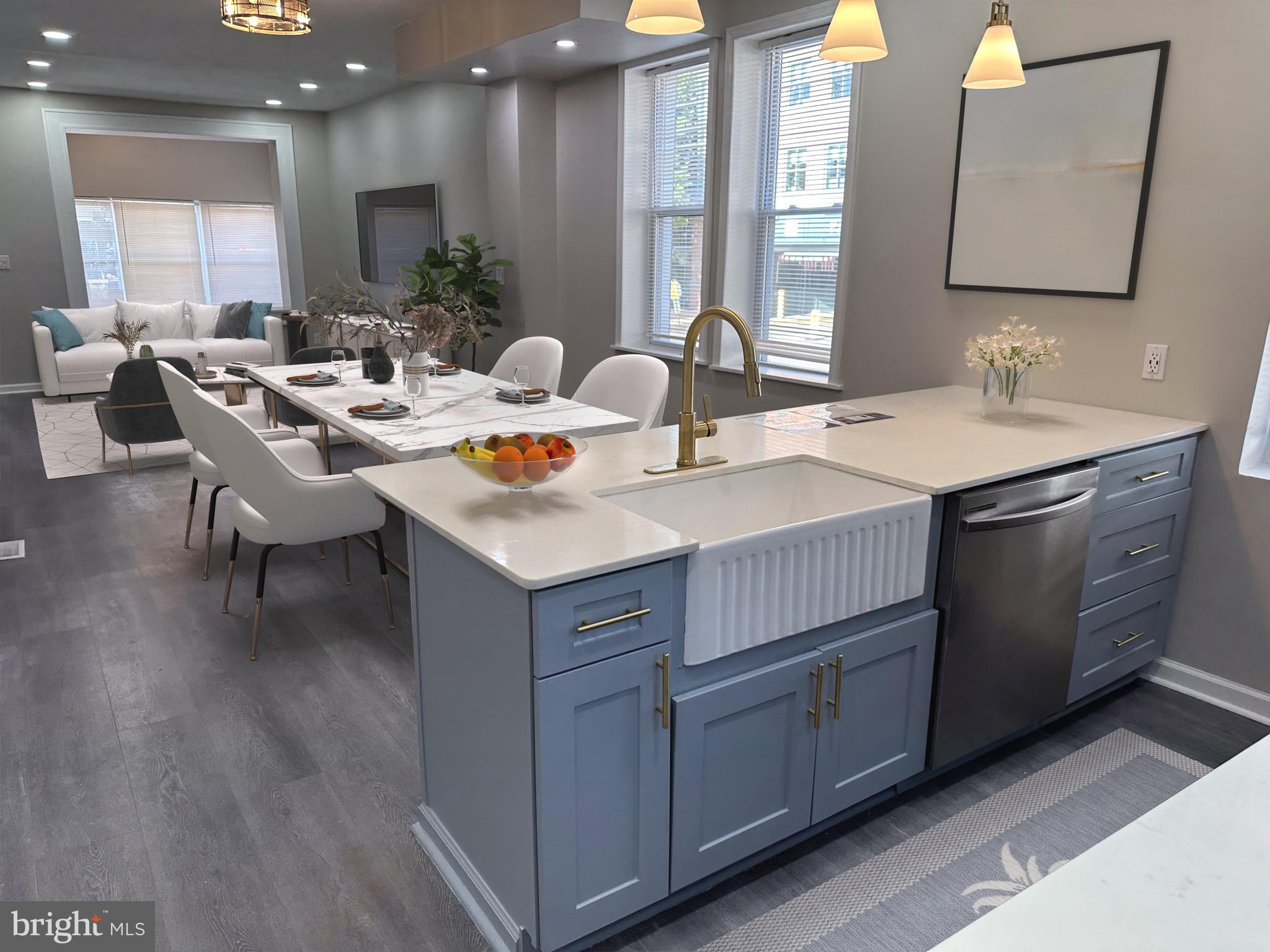 a view of kitchen island a sink wooden floor and a living room