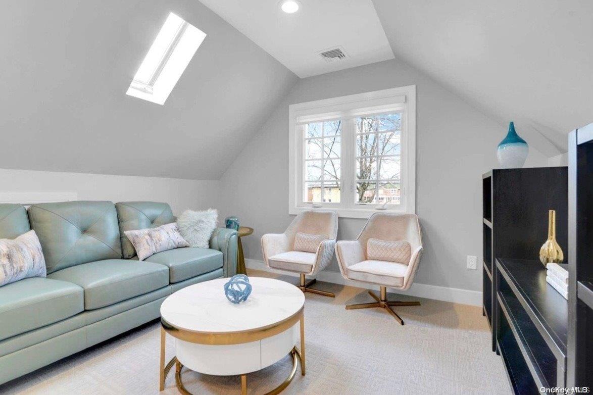 a living room with furniture a window and a flat screen tv