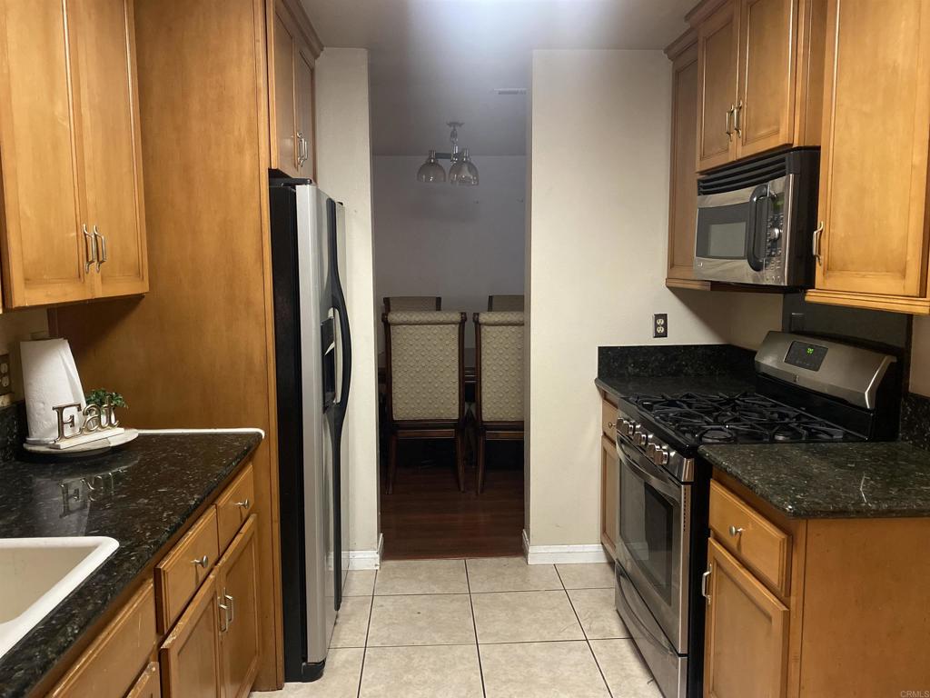 a kitchen with granite countertop a sink stove and refrigerator