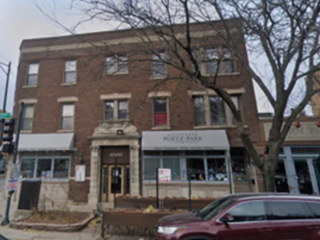 a front view of a building with that has a tree