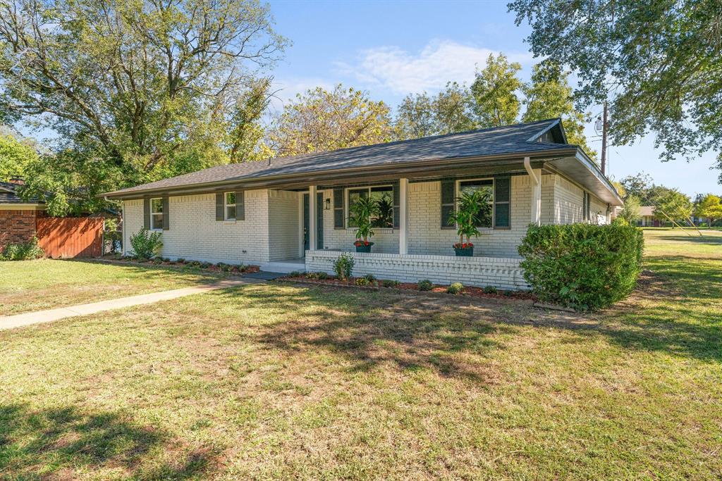 a front view of house with yard and trees around