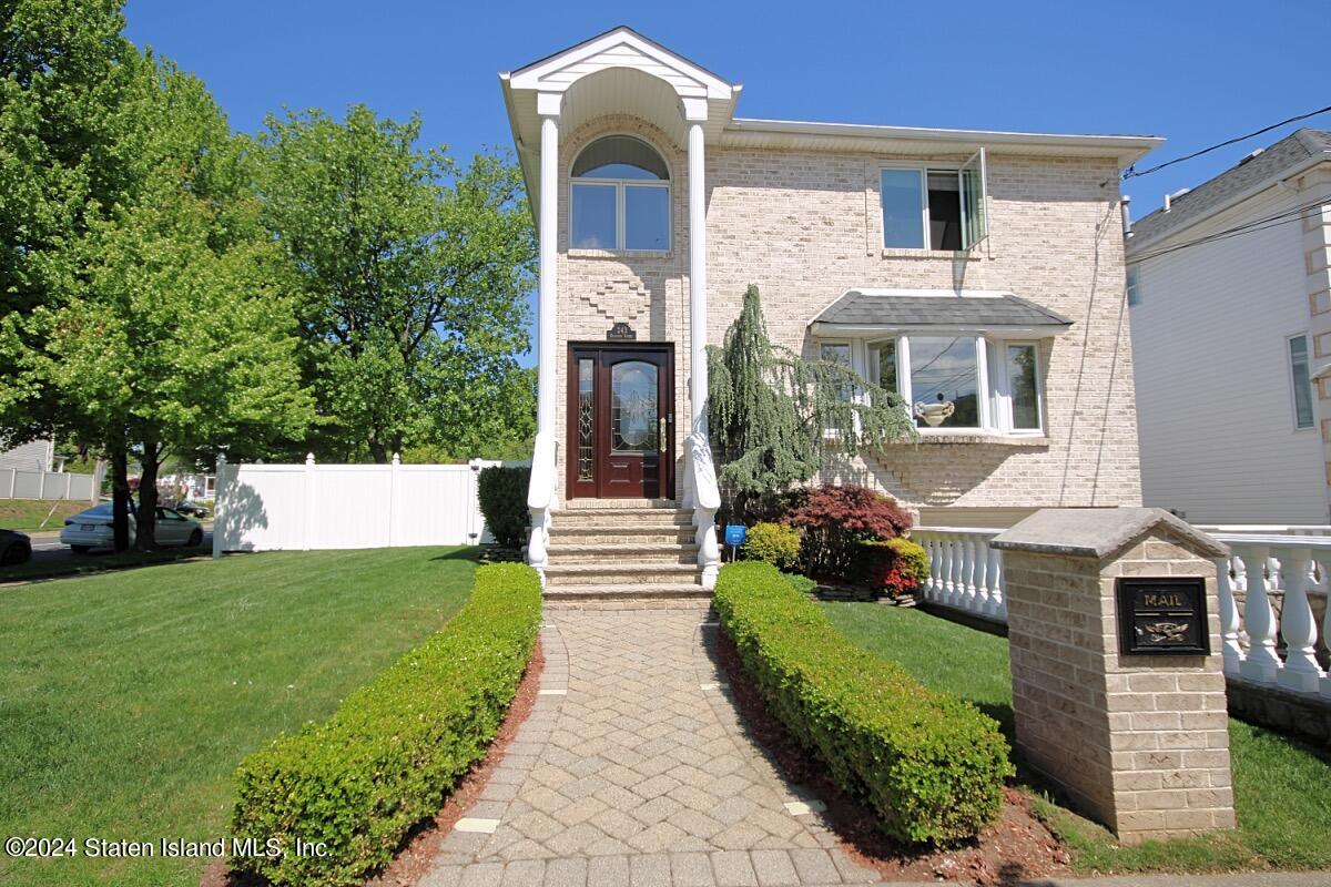 a front view of a house with a garden