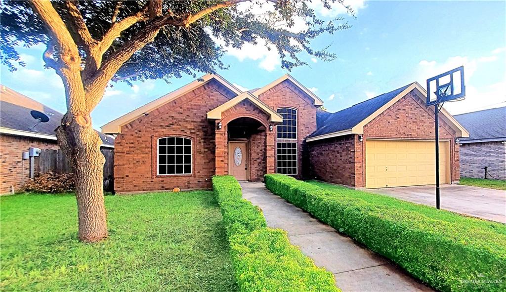 View of front of home featuring a front lawn and a garage