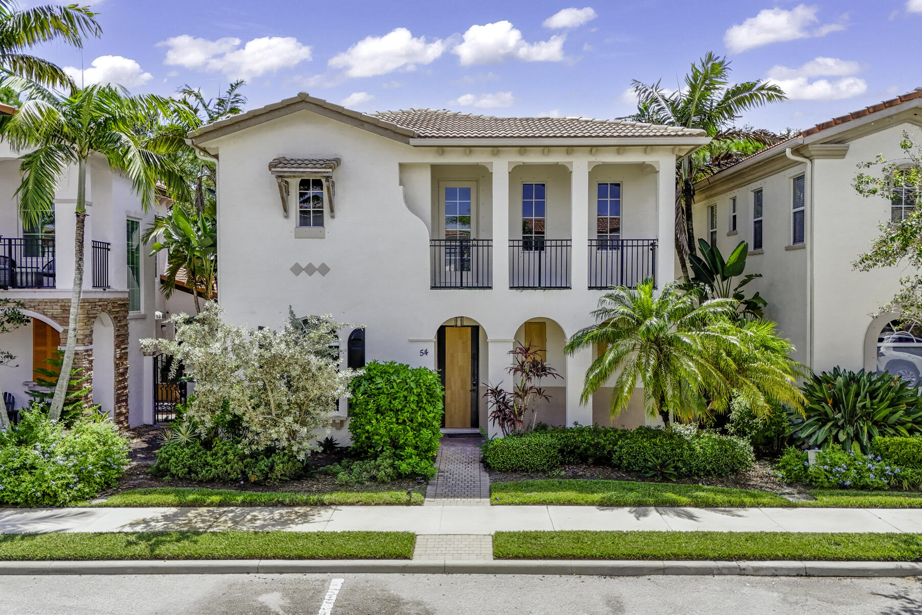 a front view of a house with a yard and potted plants