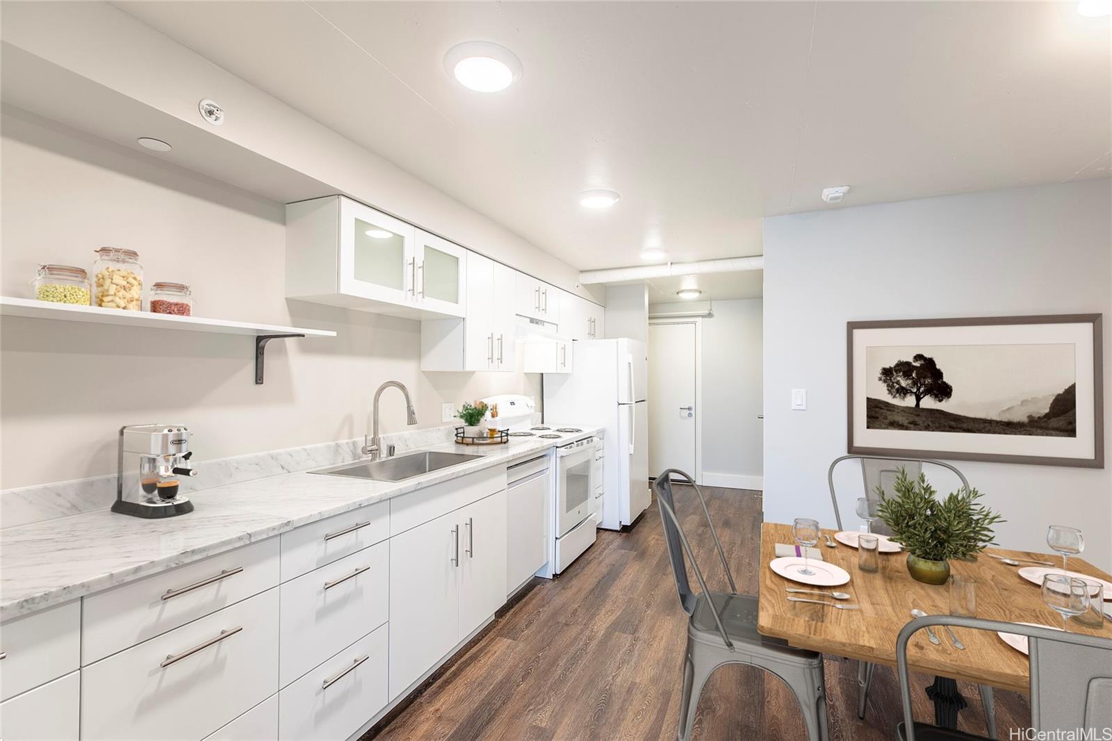 a large kitchen with stainless steel appliances a white table chairs and a refrigerator