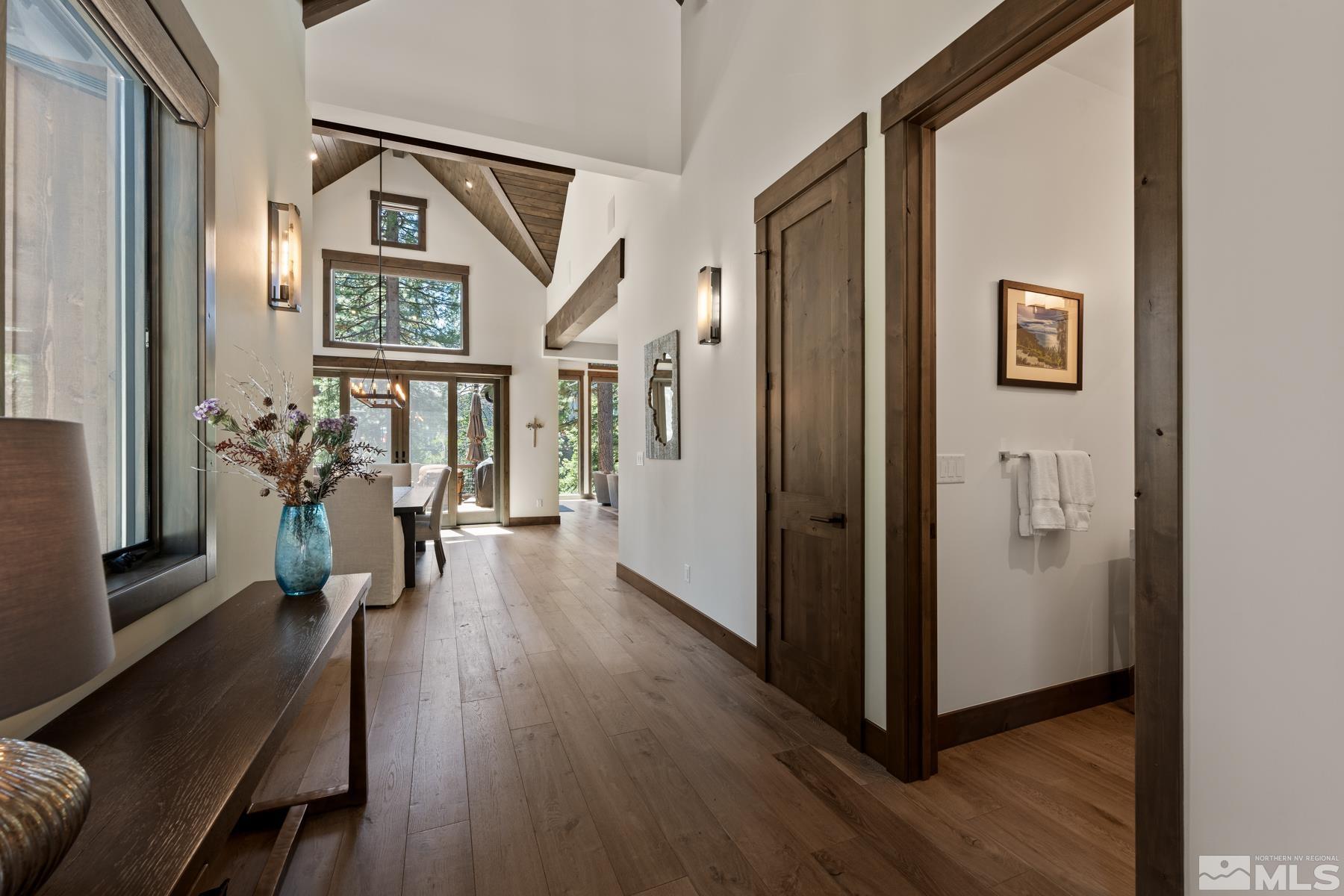 a view of a hallway with wooden floor and stairs