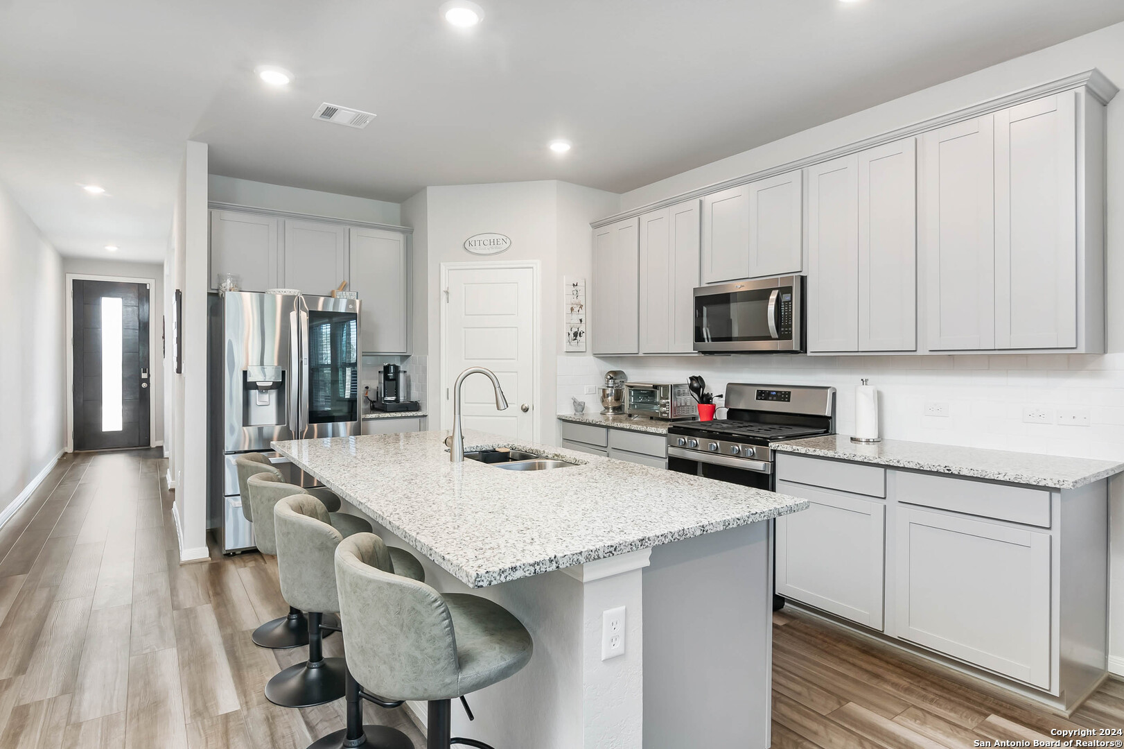 a kitchen with stainless steel appliances a sink microwave and cabinets