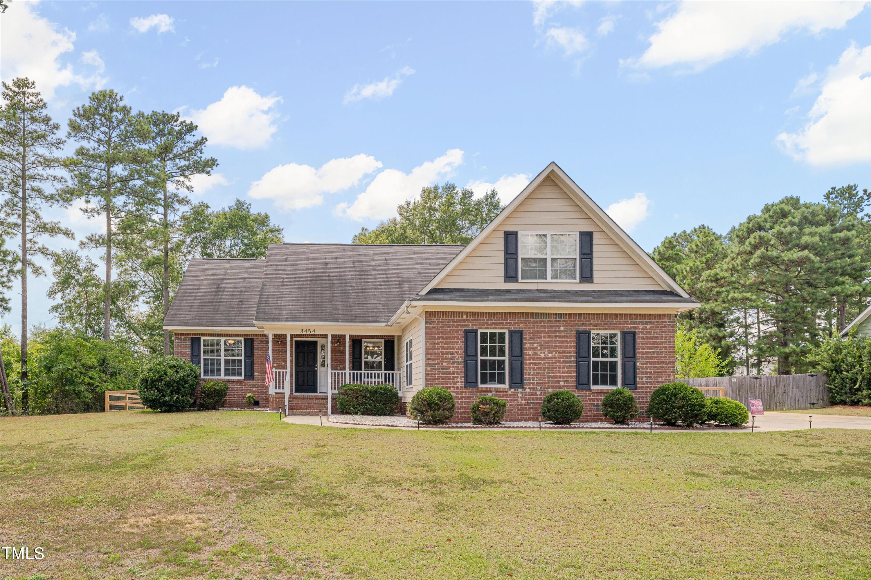 a front view of a house with a yard and trees