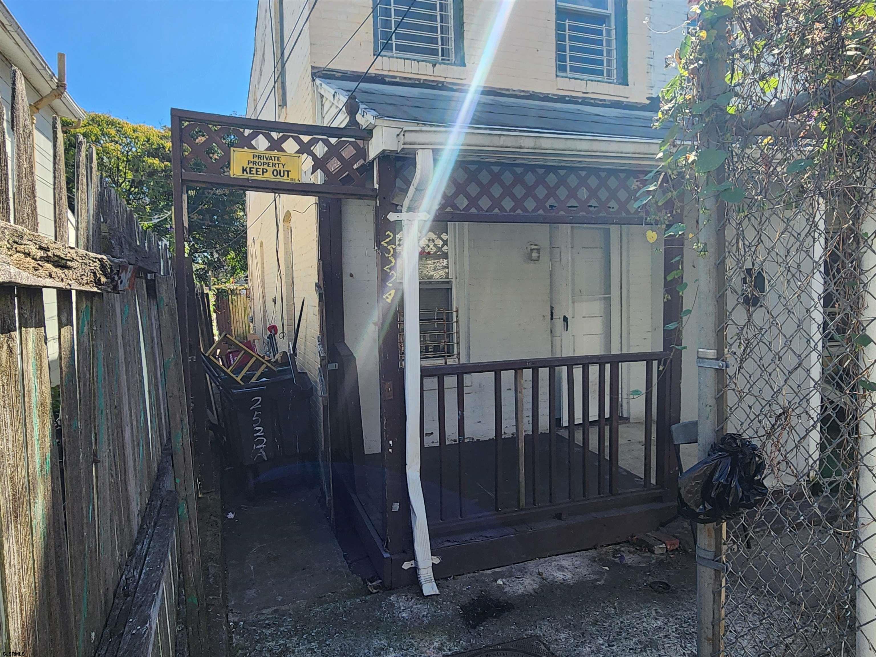 a view of a house with a door and wooden fence