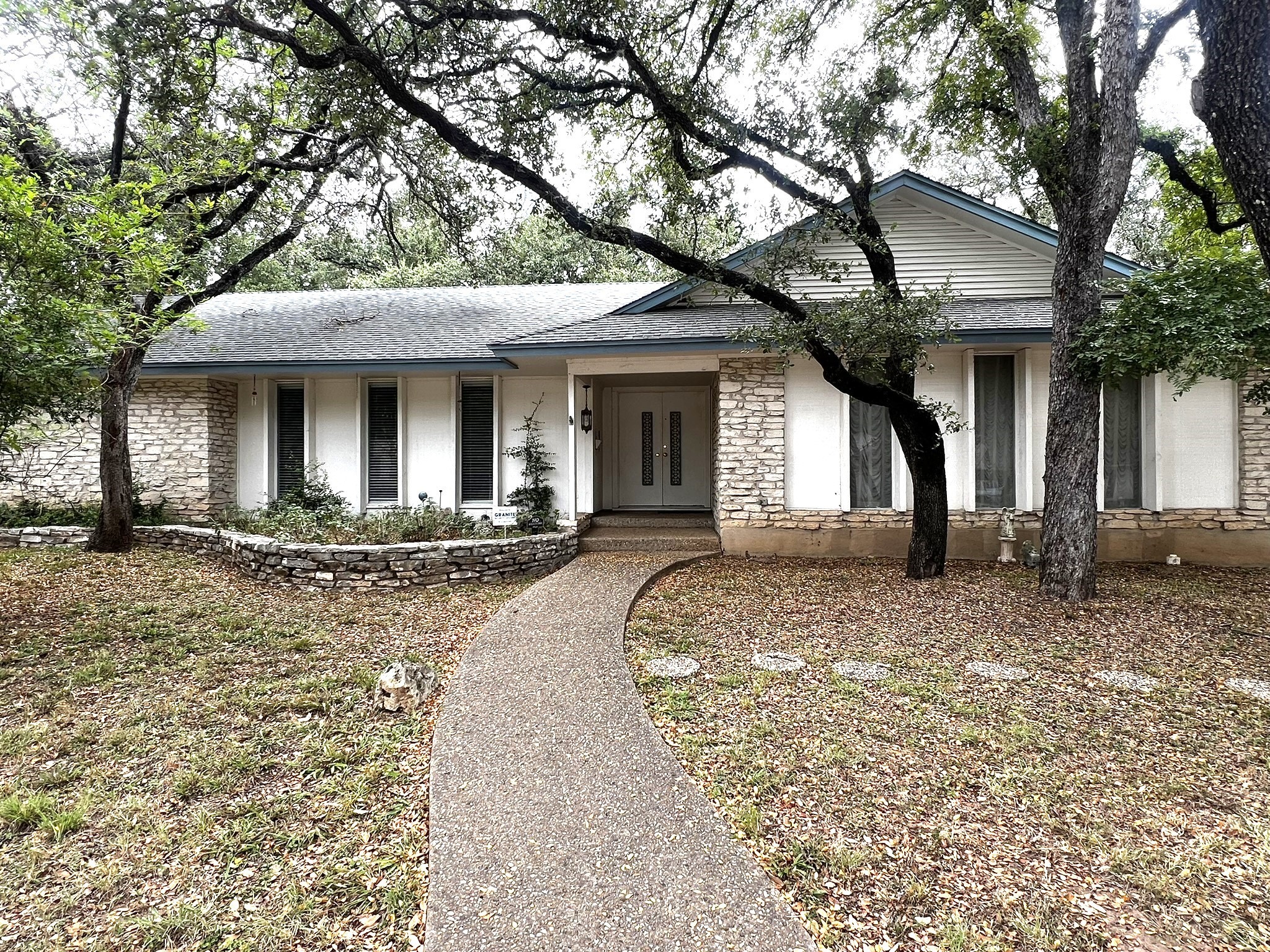 a view of a house with large windows and a tree