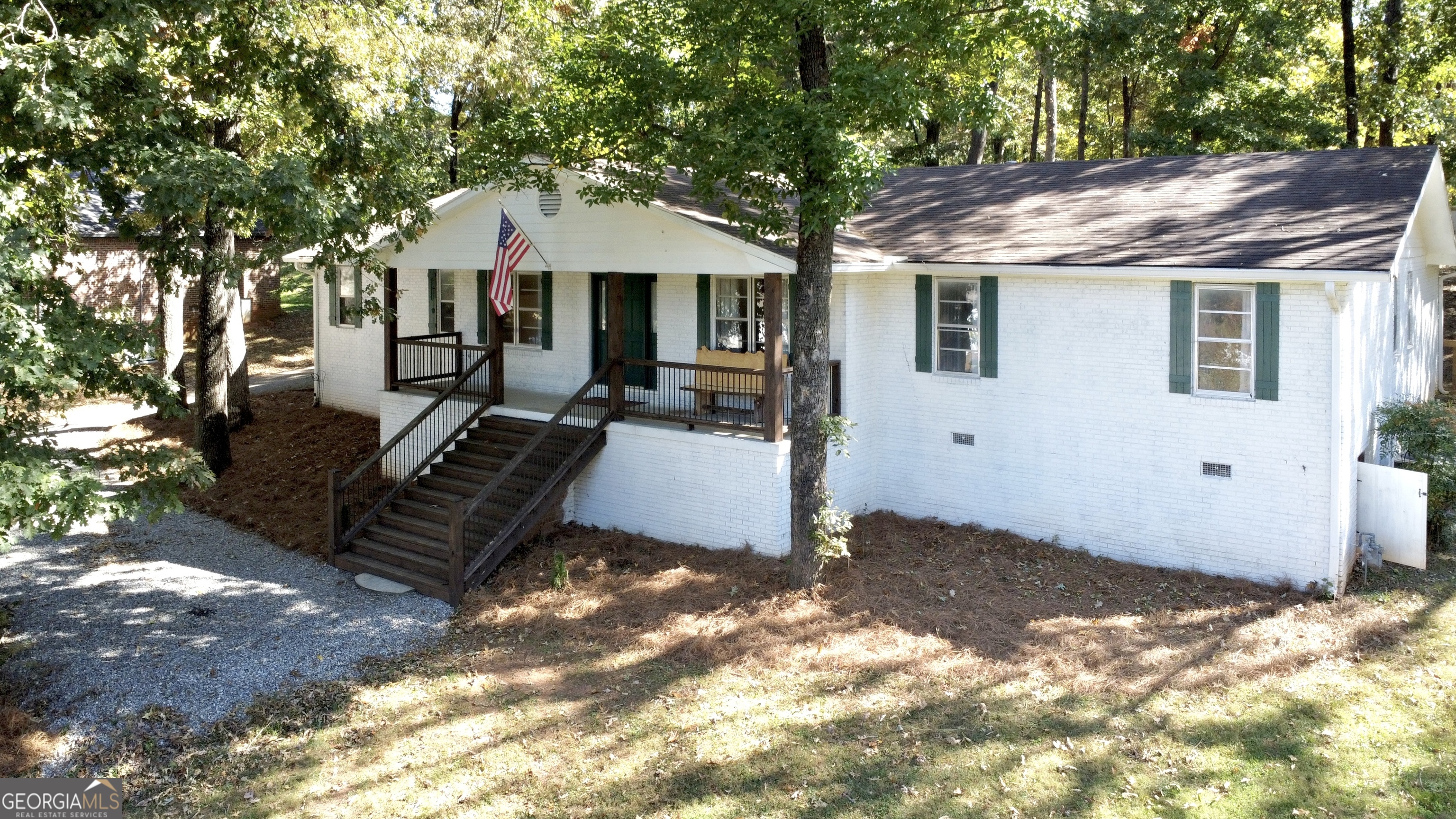 a view of a house with a large tree and a yard