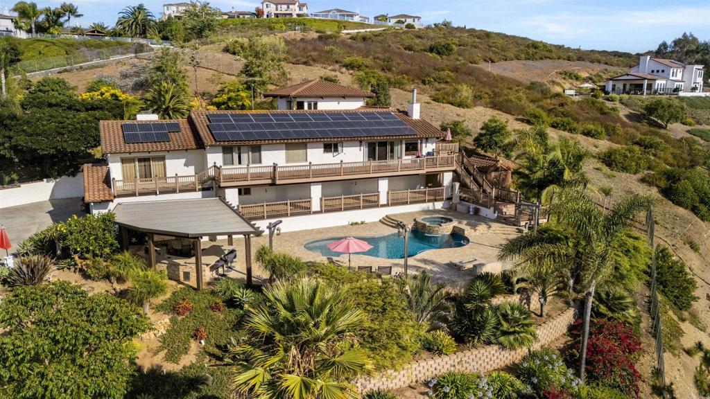 an aerial view of a house with a garden and lake view