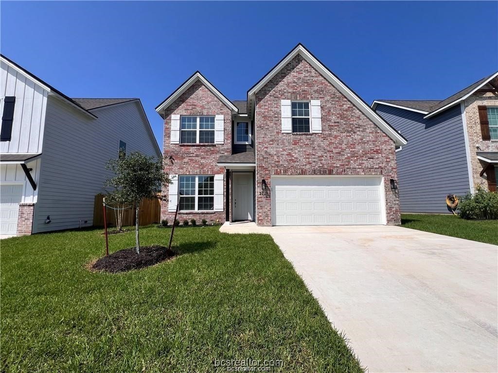 a front view of a house with a yard and garage