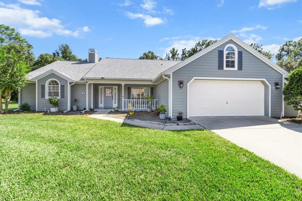 a front view of a house with yard and green space