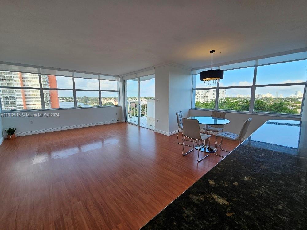 a view of a room with wooden floor and a floor to ceiling window