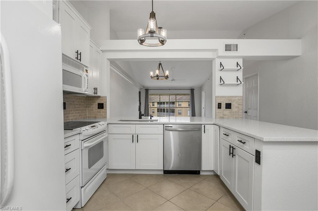 a kitchen with white cabinets and white appliances