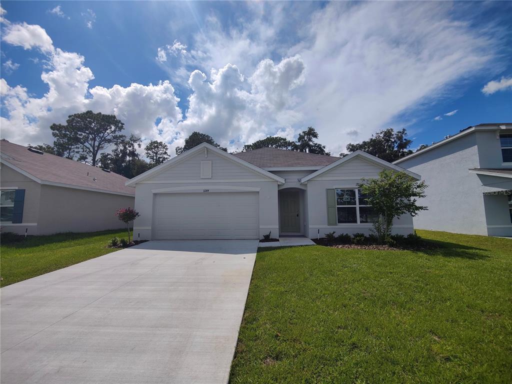 a front view of a house with a yard and garage