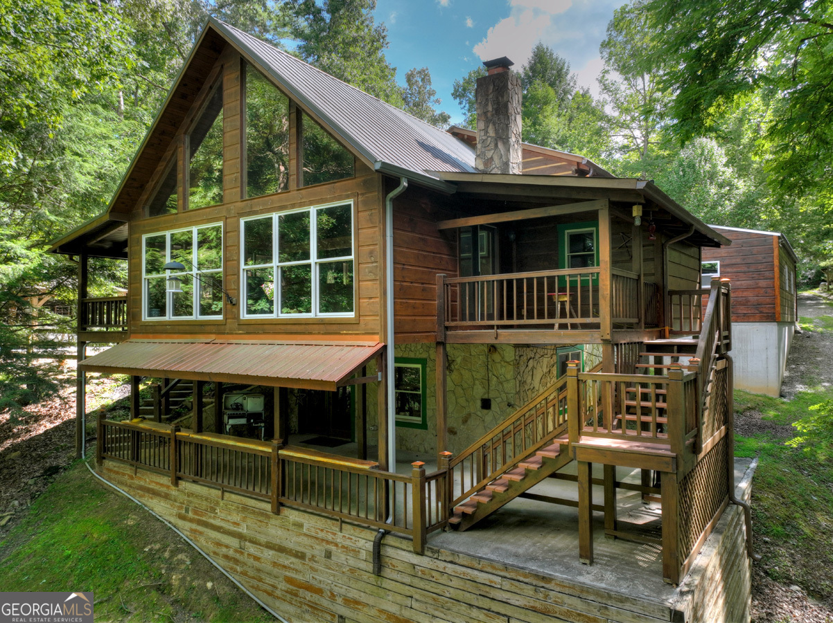 a view of house with roof deck and sitting area