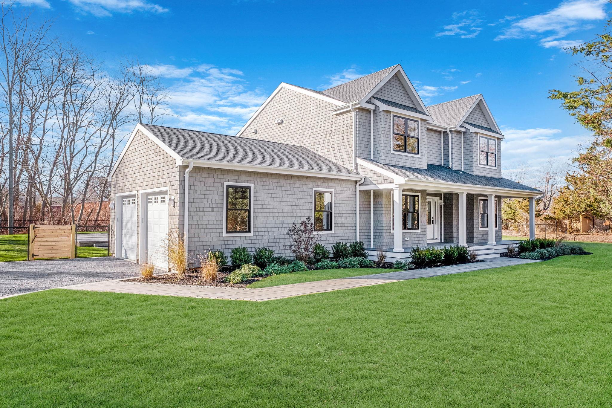 View of front of home with a front lawn, a porch, and a garage