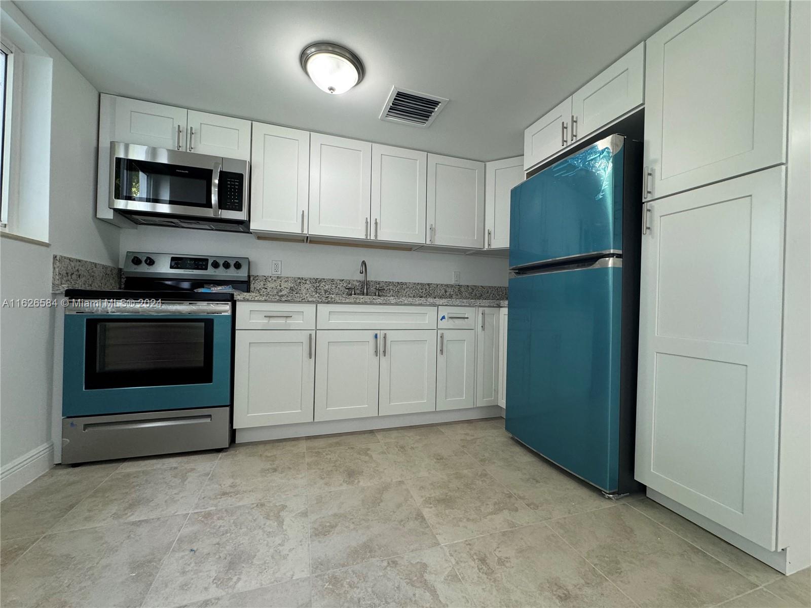 a kitchen with stainless steel appliances granite countertop a refrigerator stove a sink and dishwasher