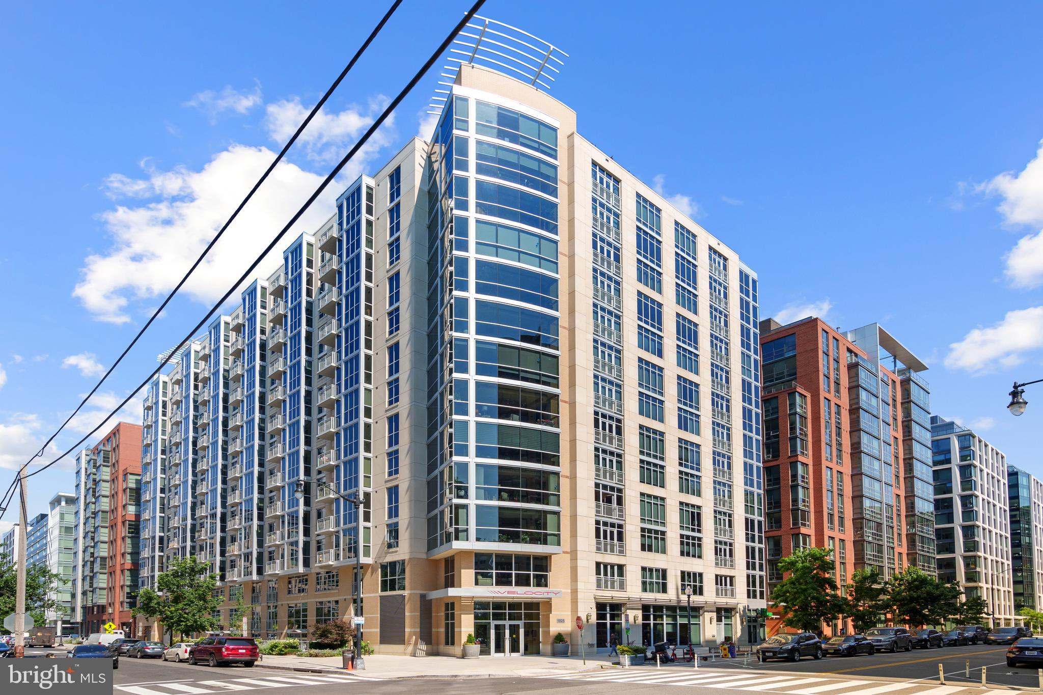 a front view of a building with lot of cars and trees