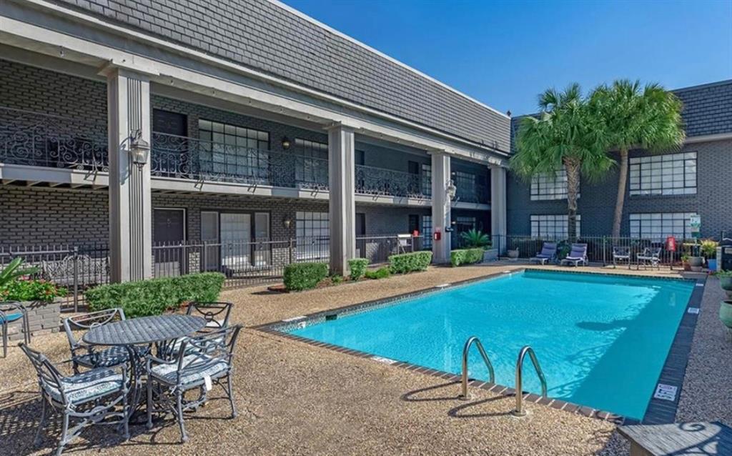 a view of a house with swimming pool and porch with furniture