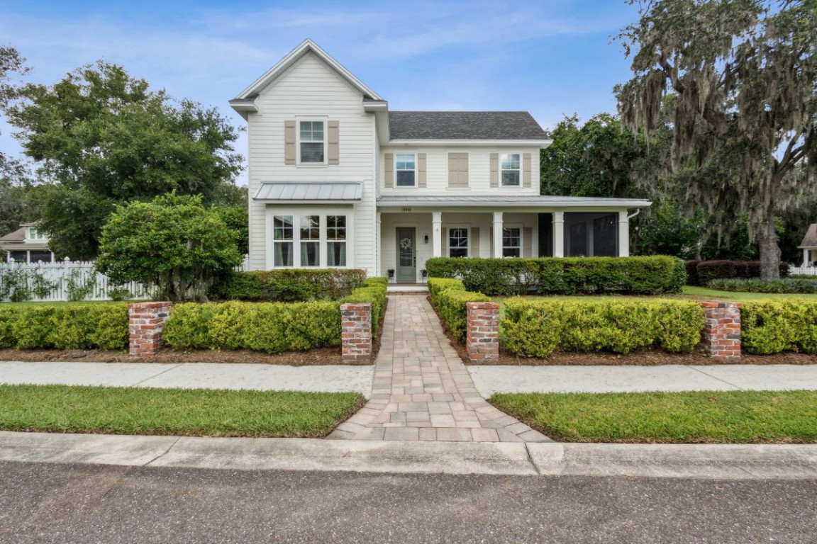 a front view of a house with a yard and potted plants