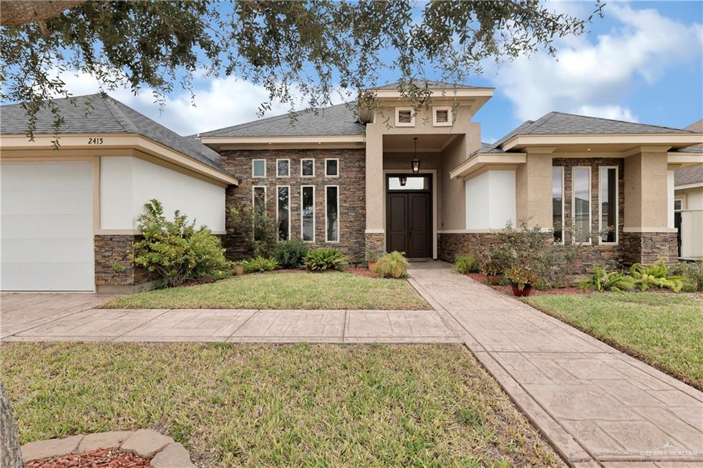 Prairie-style home with a garage and a front lawn