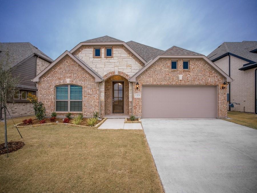 a front view of a house with large windows and fire pit